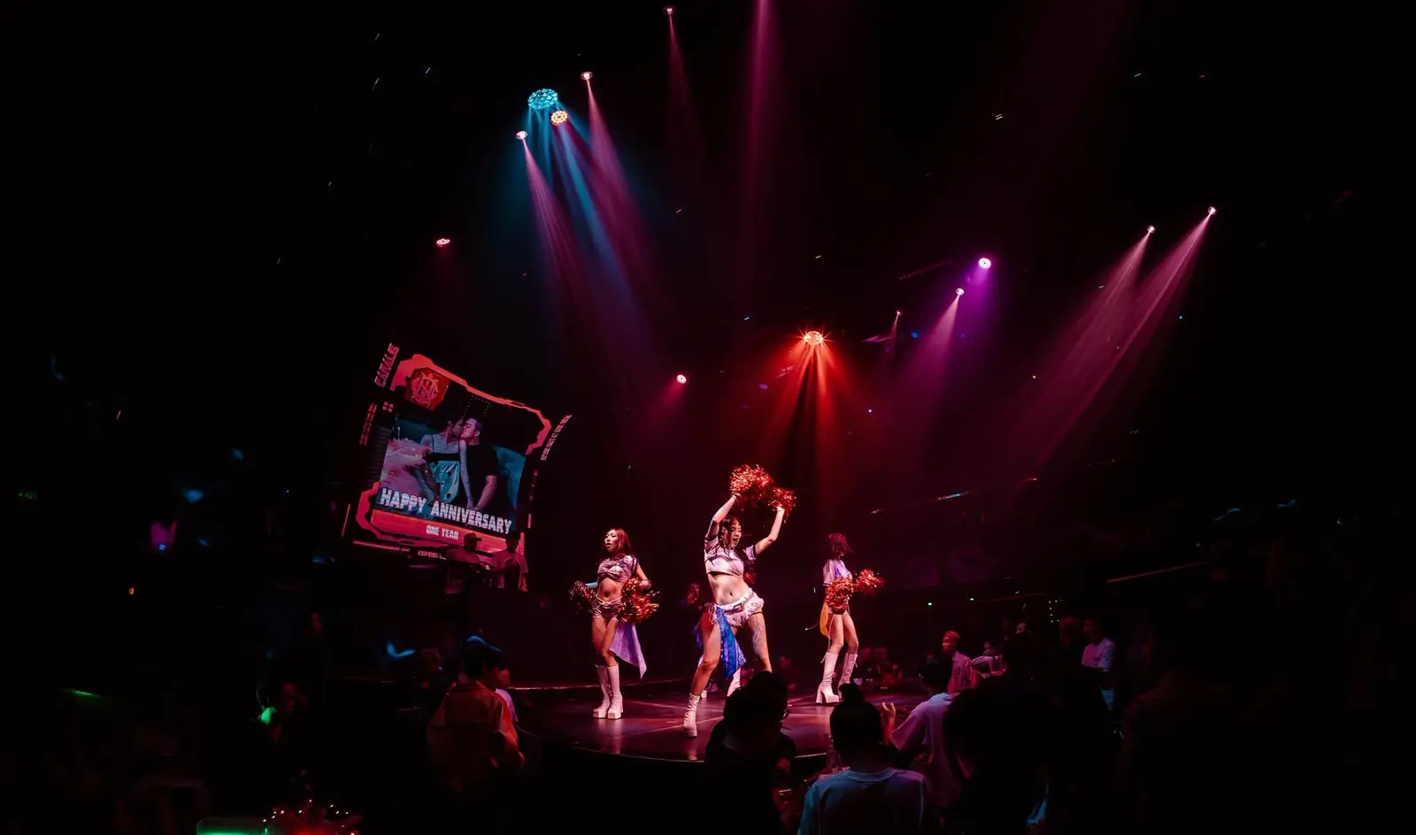 Vũ đoàn trình diễn trên sân khấu Canalis Club, màn hình LED lớn phía sau chiếu dòng chữ kỷ niệm